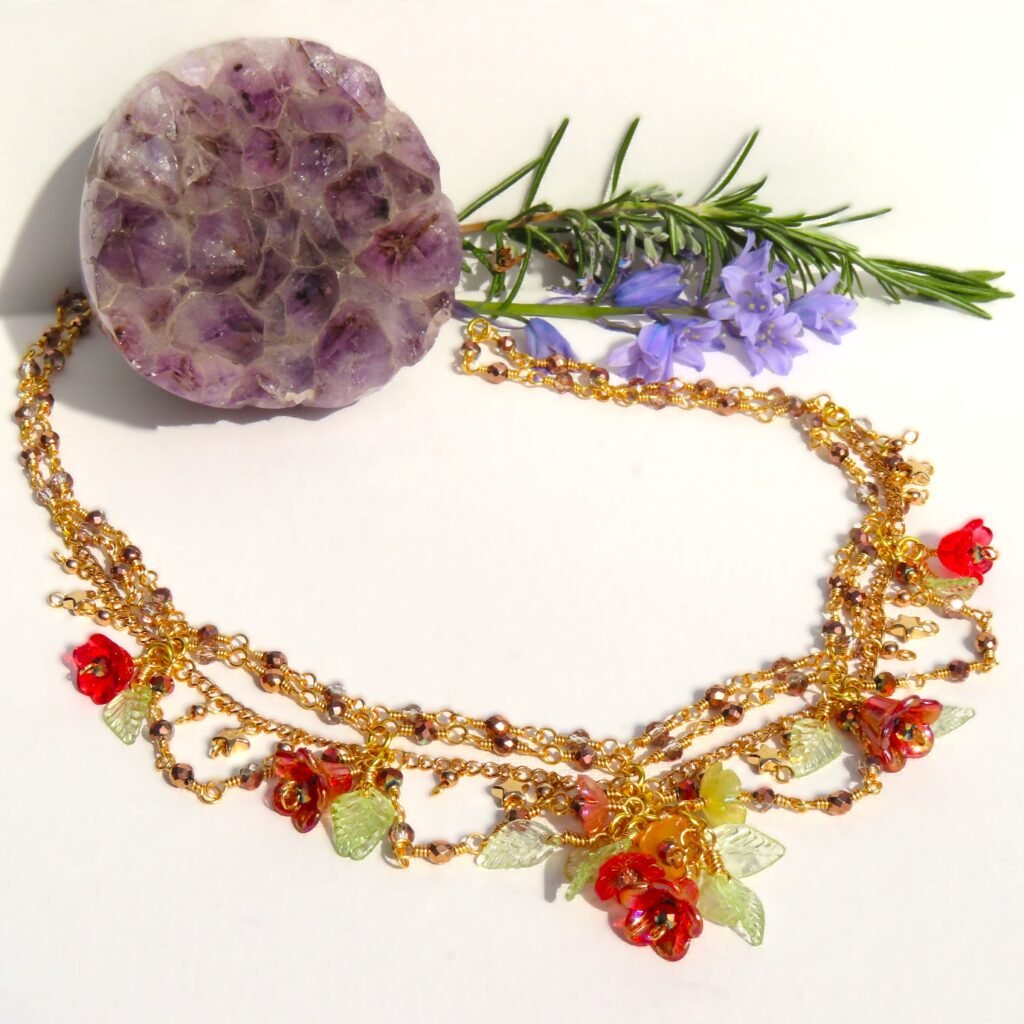 Various Lucite flowers in Autumnal shades, some hand painted are intricately linked in this layered gold tone necklace embellished with faceted Haematite and glass crystals.  Designed and crafted by Fiona of Fifi and the Peacock