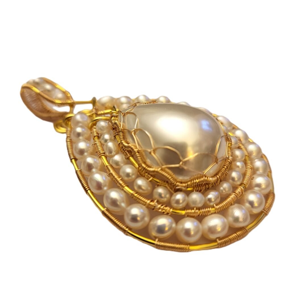 A custom made pendant featuring 2 different sizes of white Cultured Freshwater Pearls in a gilt wire framework surrounding a pear shaped cabochon made of crushed pearls.  The bezel of the pendant has been designed so it can fit over an existing pearl necklace of the customers.