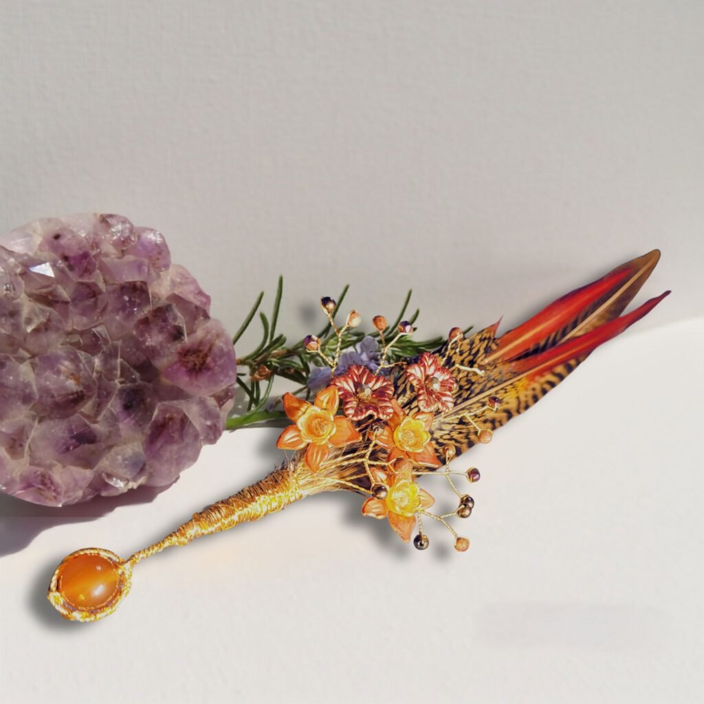 The finished custom made hatpin for the customer featuring magenta Haematite, Goldstone, gold Haematite, faceted glass crystals, Carnelian with hand painted Lucite flowers and Golden Pheasant feathers