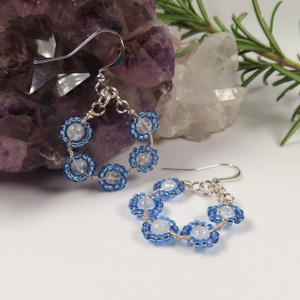 Small Dainty Bouquet earrings featuring clear crackled Quartz, surrounded by blue Miyuki seed beads on silver toned wire with silver plated ear wires.  Designed and crafted by Fiona of Fifi and the Peacock