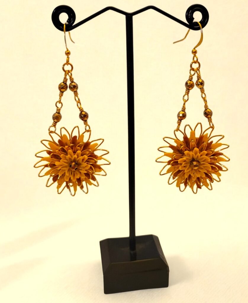 A one off design inspired by the track Dandelions on the Can't Take My Story Away album by Elles Bailey.  Dandelion inspired earrings made with Fimo Polymer Clay encased in a gilt wire frame with rose gold coloured Haematite.  Designed and crafted by Fiona of Fifi and the Peacock as a gift to Elles for the launch of her new album