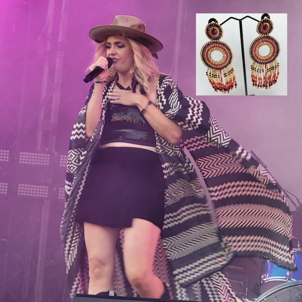 A picture taken by Fiona at Scarborough Open Air Theatre of Elles Bailey on stage opening for Rag 'n' Bone Man in July 2025.  Inset picture of earring that Elles was wearing, made and designed by Fiona of Fifi and the Peacock