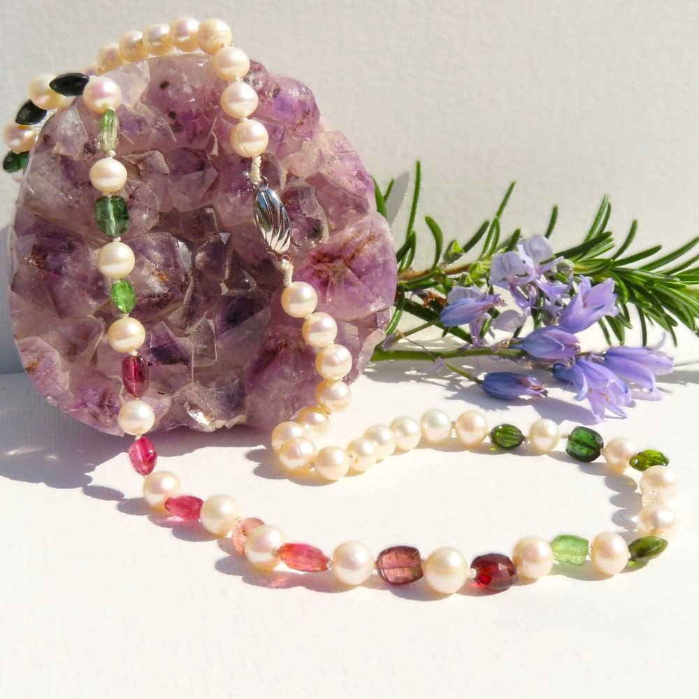 White Cultured Freshwater Pearls interspersed with multi coloured Tourmaline in faceted shield shape beads.  Hand knotted in the traditional technique and finished with a sterling silver clasp.  Designed and crafted by Fiona of Fifi and the Peacock
