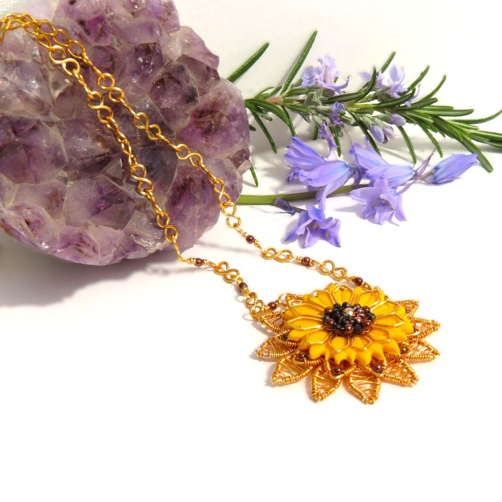 Sunflower necklace featuring a multiple wirework layers with bronze Haematite.  Encased in the wire work is a Fimo Polymer Clay sunflower and the centre is embellished with Haematite, faceted Spinel and Miyuki seed beads.  Suspended from a handcrafted chain.  Designed and crafted by Fiona of Fifi and the Peacock
