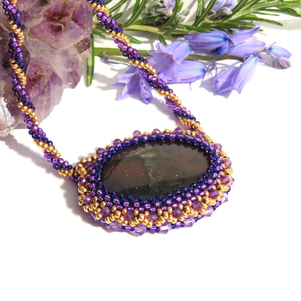 Large purple flash Labradorite cabochon with a Miyuki seed bead, faceted Amethyst and glass crystal bezel suspended from a twisted Herringbone design chain.  Designed and crafted by Fiona of Fifi and the Peacock
