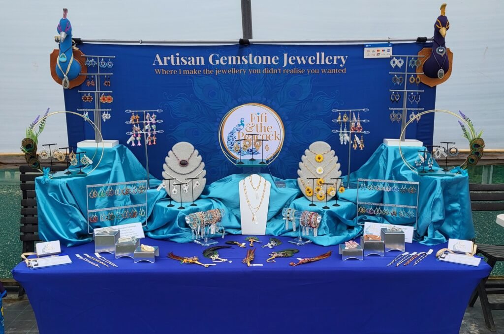 Picture of the Fifi and the Peacock stand set up for indoor events showcasing the range of jewellery designed and crafted by Fiona.