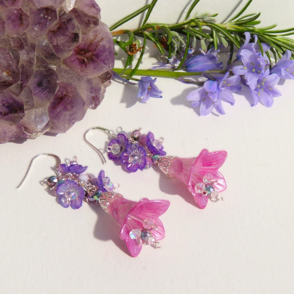 Pink and silver large foxglove shaped flower with Haematite and glass crystal drops from the centre, the top is a cluster of small purple flowers.  Designed and crafted by Fiona of Fifi and the Peacock