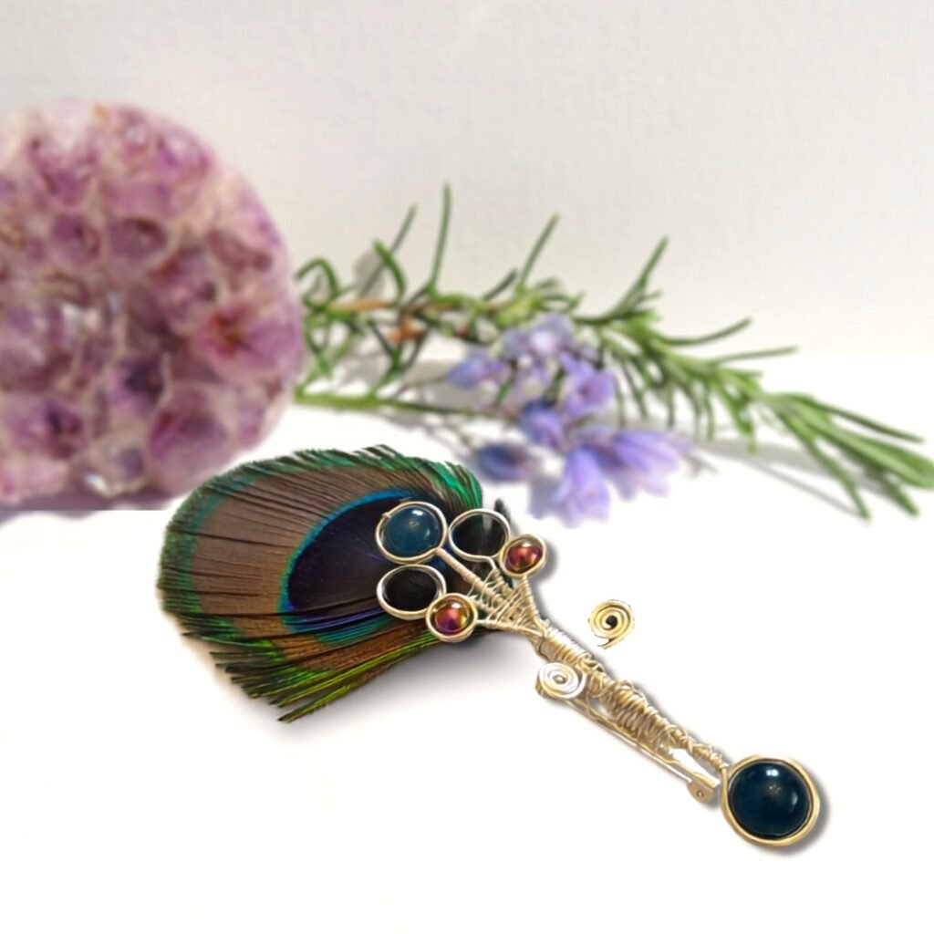 Can be worn fixed to your hat with the brooch pin on the back or worn on your jacket of choice.  Crafted from silver plated copper wire with dyed blue Agate, dyed green Tiger Eye and Rainbow Haematite.  Suitable for a wedding for the groom and groomsmen as well as a day at the races.  Designed and crafted by Fiona of Fifi and the Peacock
