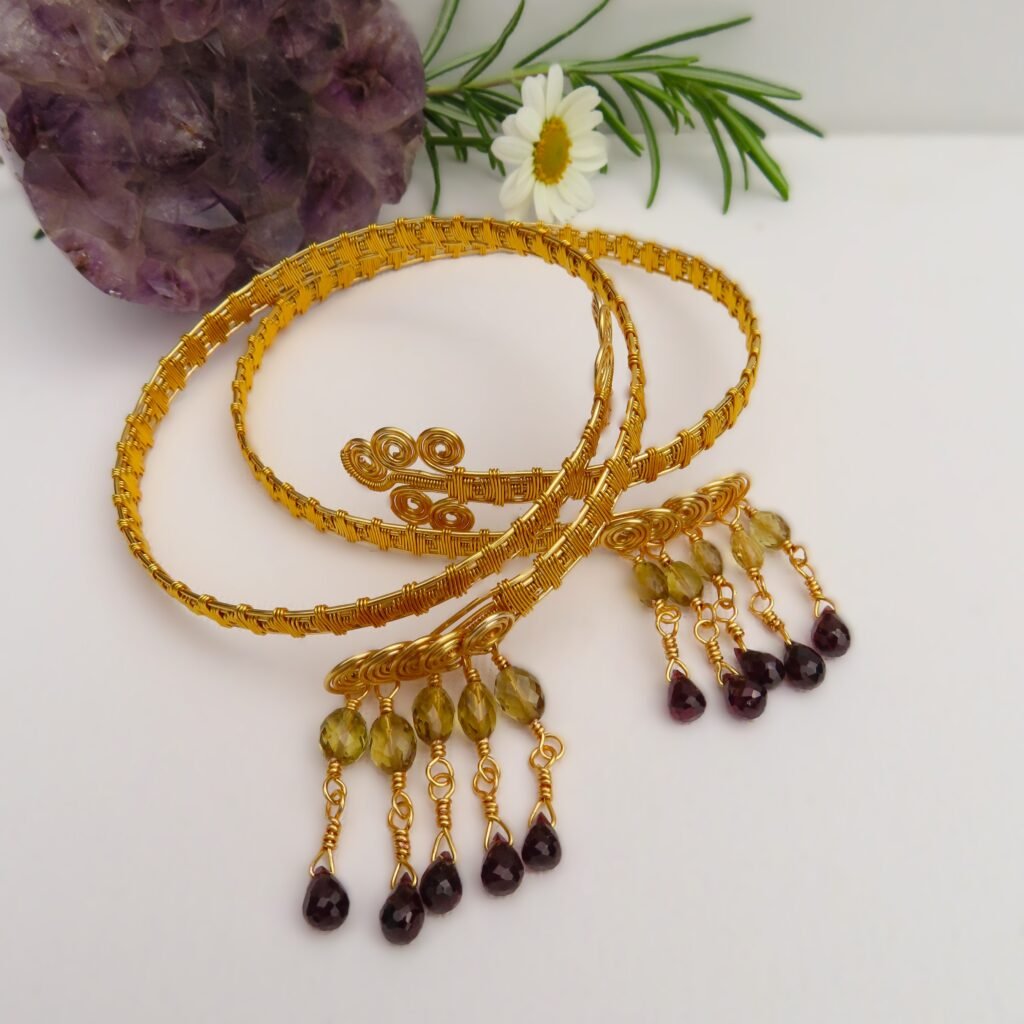 A very unique design, handcrafted in gilt wire using wire wrapping and featuring drops of faceted Champagne Quartz finished with faceted Garnet Briolettes.  Made and designed by Fiona of Fifi and the Peacock