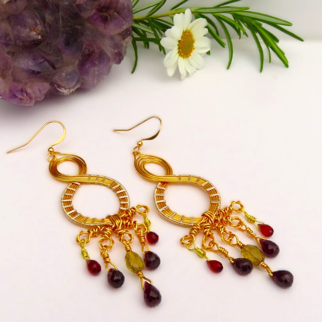 Custom design and and handcrafted by Fiona of Fifi and the Peacock.  Gilt wirework earrings featuring faceted Garnet Briolettes and facted Champagne Quartz on gold plated ear wires
