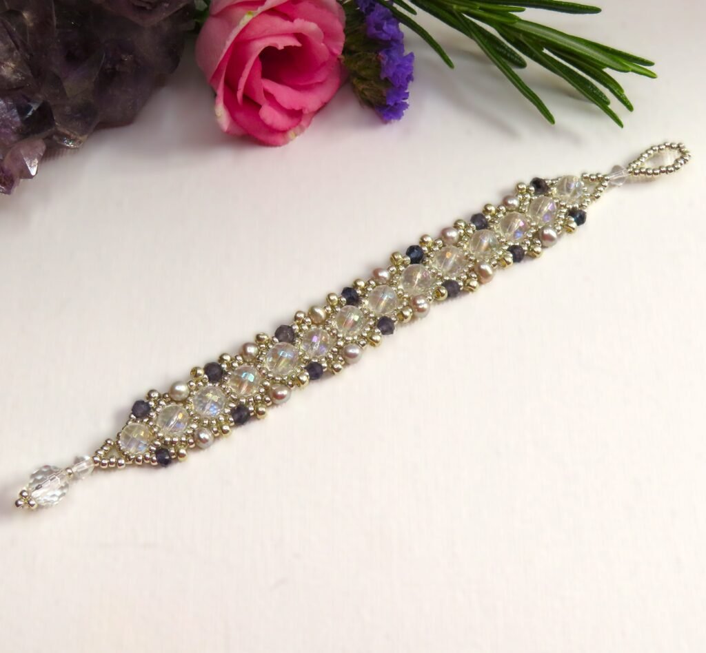 Handcrafted by Fiona of Fifi and the Peacock a Miyuki seed bead bracelet featuring a central row of faceted Clear Quartz and embellished with micro faceted Iolite and silver coloured Cultured Freshwater Pearls.
